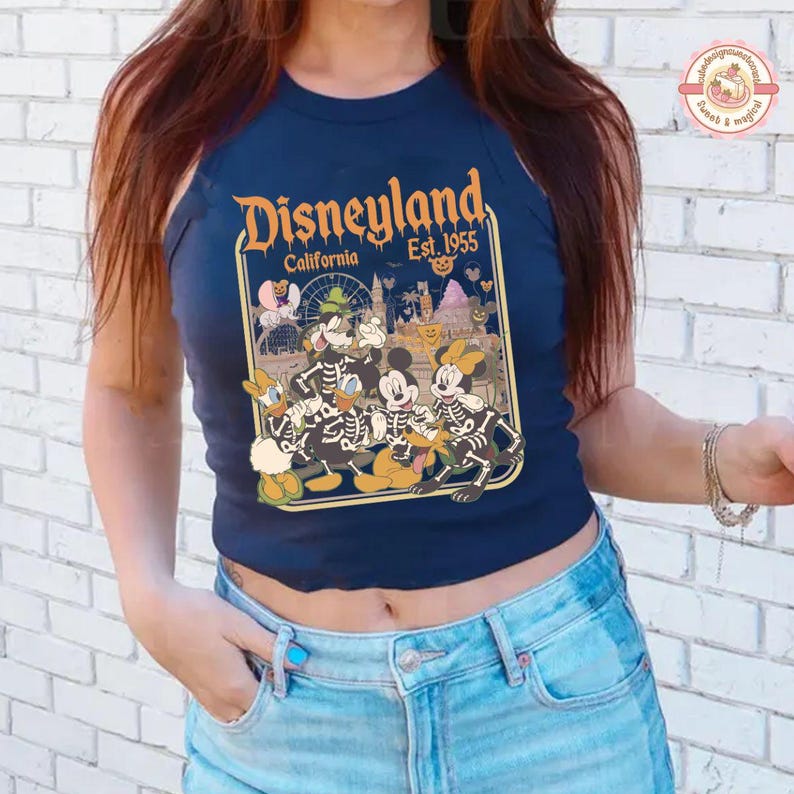 K&ouml;nnte beinhalten: Marineblaues Tanktop mit Disneyland-Grafik. Die Grafik zeigt Mickey, Minnie, Donald und Goofy als Skelette verkleidet. Der Text lautet "Disneyland California Est. 1955" in Orange.