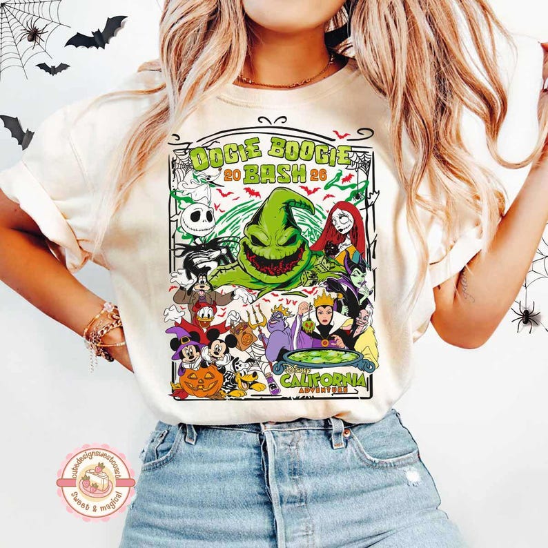K&ouml;nnte beinhalten: Ein cremefarbenes T-Shirt mit einem Grafikdruck und dem Text OOGIE BOOGIE BASH 2026 CALIFORNIA ADVENTURE. Das Design enth&auml;lt Illustrationen von Oogie Boogie, Jack Skellington, Sally, Mickey Mouse, Donald Duck und weiteren Charakteren.