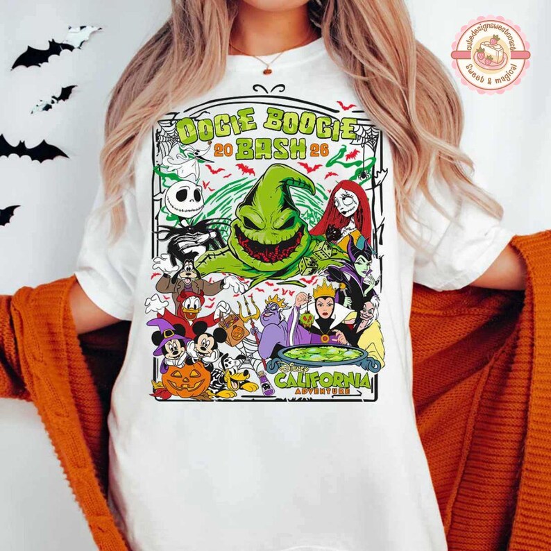 K&ouml;nnte beinhalten: Ein wei&szlig;es T-Shirt mit einem Grafikdruck mit dem Titel Oogie Boogie Bash 2026. Das Design enth&auml;lt Illustrationen verschiedener animierter Figuren, eine gr&uuml;ne Kreatur, einen Kessel, K&uuml;rbisse und Flederm&auml;use sowie den Text Disney California Adventure.