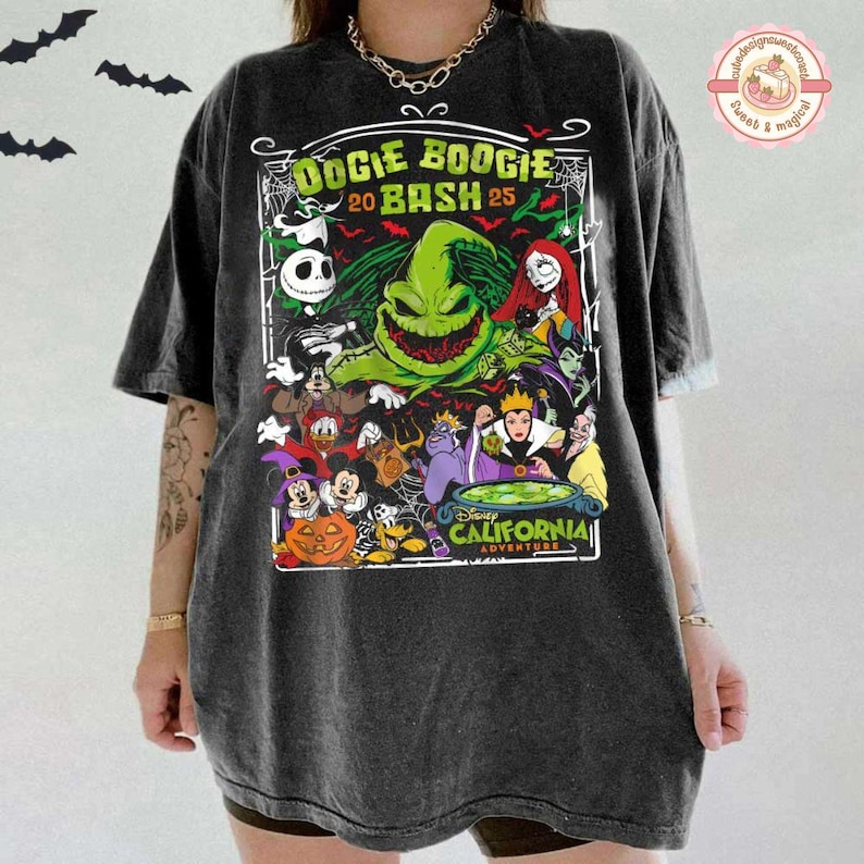 K&ouml;nnte beinhalten: Ein anthrazitfarbenes T-Shirt mit einem Grafikdruck mit dem Text Oogie Boogie Bash 25 und Disney California Adventure. Das Design enth&auml;lt Illustrationen verschiedener Zeichentrickfiguren, ein gr&uuml;nes Monster, einen K&uuml;rbis und Spinnennetze.