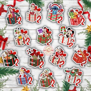 May include: A collection of Christmas-themed stickers featuring various Disney characters popping out of gift boxes. The stickers have red ribbons and are set against a white wooden background with festive decorations.