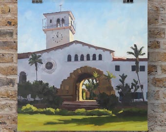 May include: A square art print depicting a white building with a tall clock tower, a large arched entryway, and a circular window. The scene includes green palm trees and a grassy foreground under a light blue sky, signed by the artist.