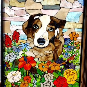 May include: A stained glass window depicting a brown and white dog with blue eyes, surrounded by colorful flowers. The dog is looking directly at the viewer.