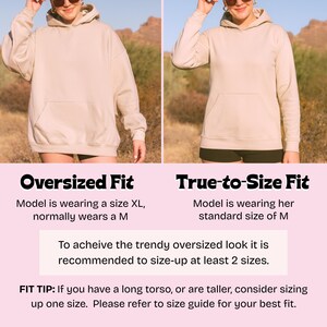 K&ouml;nnte beinhalten: Zwei nebeneinander liegende Bilder zeigen einen beigefarbenen Hoodie in Oversize- und True-to-Size-Passform. Text erkl&auml;rt, wie man einen Oversize-Look durch Hochstufen der Gr&ouml;&szlig;e erzielt. Der Hoodie hat eine Vordertasche und eine Kapuze.