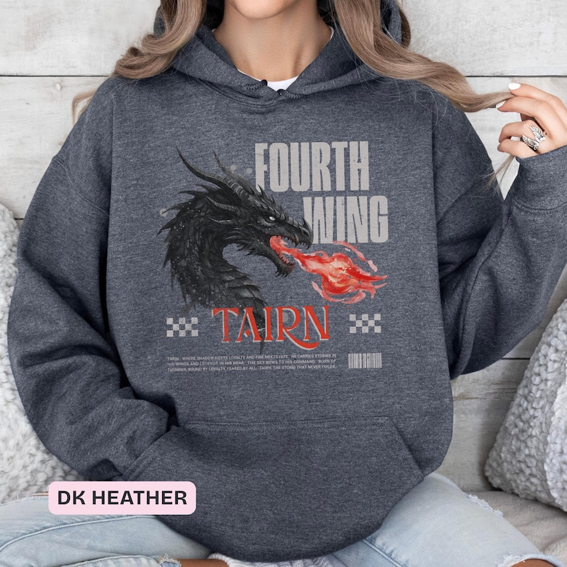 K&ouml;nnte beinhalten: Dunkelgrauer Kapuzenpullover mit einem schwarzen Drachen, der rote Flammen speit. Auf der Vorderseite sind die Texte "FOURTH WING" und "TAIRN" aufgedruckt. Der Hoodie hat eine Kapuze mit Kordelzug und eine K&auml;ngurutasche.