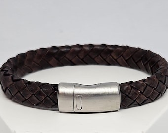 May include: A brown leather bracelet with a braided design and a silver magnetic clasp.