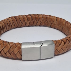 Könnte beinhalten: Ein braunes Lederarmband mit geflochtenem Design und einem silbernen Metallverschluss.