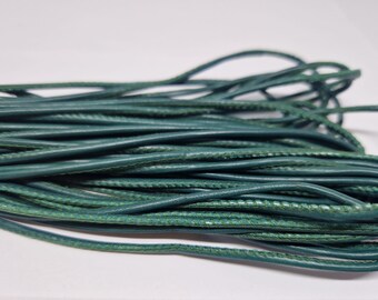 May include: A close-up of a bundle of teal green leather cord. The cord is stitched with a contrasting green thread.