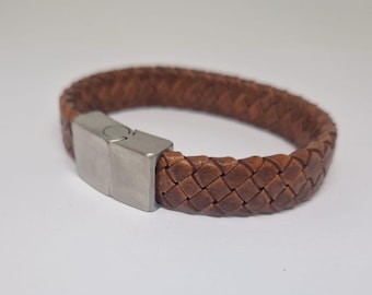 May include: A brown leather bracelet with a braided design and a silver magnetic clasp.