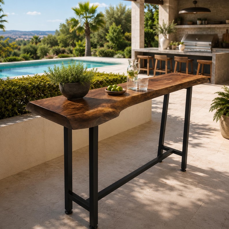 May include: A tall bar table featuring a natural live-edge wood slab top with a rich brown grain, supported by a sturdy black metal frame with four legs and a horizontal support bar. The surface holds a potted green plant and a glass pitcher.