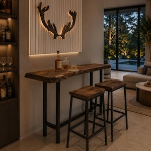 Könnte beinhalten: Ein hoher Bartisch mit einer dunklen Holzplatte mit Naturkante und schwarzen Metallbeinen, begleitet von zwei passenden Barhockern aus Holz mit schwarzem Metallrahmen. Über dem Tisch befindet sich eine dunkle Geweih-Wandskulptur.