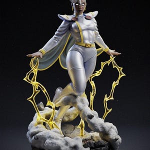 Puede incluir: Estatua plateada de Tormenta, personaje de X-Men, con cabello blanco y un traje blanco y amarillo. La figura está posando con los brazos extendidos, rodeada de rayos dorados y una base de nubes.