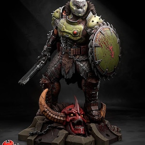 May include: A detailed figurine of a character in green and brown armor, holding a gun and shield. The shield has a red symbol and blood splatter. The figure stands on a base with a red demon head. The text "PATREON h3llcreator" is visible.