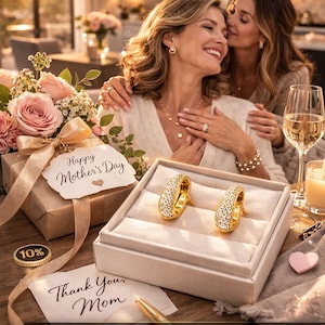 Puede incluir: Pendientes de oro con un grupo de vidrio, presentados en una caja blanca. La imagen incluye una caja de regalo con una etiqueta "Happy Mother's Day", una tarjeta "Thank You, Mom" y el texto "PHILIP FILEWYCH Treasures".
