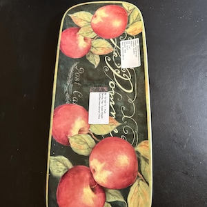 May include: Rectangular serving tray with a dark green background and a decorative apple design. The tray features red apples with green leaves and the words "La Pomme" and "Post Card" in white script. The tray is approximately 40 cm long.
