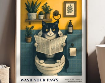 Könnte beinhalten: Gerahmter Kunstdruck mit einer schwarz-weißen Katze auf einer Toilette, die eine Zeitung liest. Das Kunstwerk hat eine gelbe und türkisfarbene Farbgebung und enthält den Text "WASH YOUR PAWS". Der Druck wird in der Nähe einer weißen Badewanne gezeigt.
