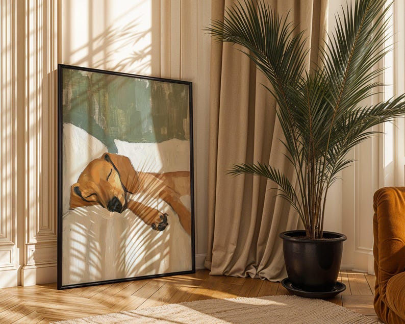 Peut inclure: Une peinture encadr&eacute;e d'un chien brun dormant sur un lit blanc. La peinture est dans un cadre noir et est accroch&eacute;e &agrave; un mur dans une pi&egrave;ce avec des rideaux beiges et un palmier en pot.