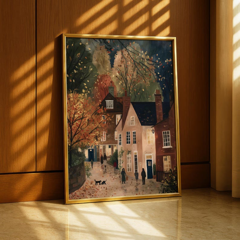K&ouml;nnte beinhalten: Gerahmtes Gem&auml;lde, das eine malerische Stra&szlig;enszene mit H&auml;usern und Figuren darstellt. Das Kunstwerk zeigt warme Herbstfarben mit B&auml;umen in Orange- und Rott&ouml;nen. Das Gem&auml;lde befindet sich in einem goldenen Rahmen und lehnt an einer Holzwand.