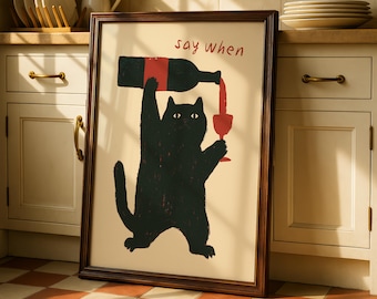 May include: A framed art print featuring a black cat pouring wine into a glass from a bottle. The cat is standing upright, and the text "say when" is above the bottle. The artwork has a whimsical, cartoonish style.