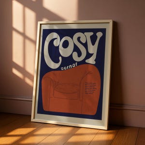 May include: Framed art print with a retro illustration. The artwork shows the words "COSY corner" in white, above an orange armchair on a navy blue background. A poem is printed below the chair.