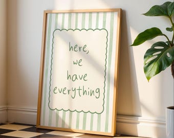 May include: A framed print with a light wood frame. The print has a cream-colored background with green and white vertical stripes. The center features the words "here, we have everything" in a handwritten style font.