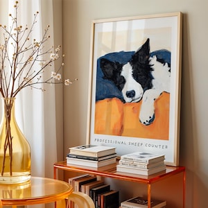 Border Collie dog illustration styled on wooden sideboard with vase and coffee table – minimalistic pet portrait wall art.