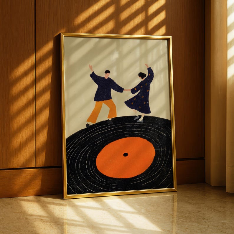 以下が含まれることがあります： レコードの上で踊るカップルを描いた額入りのアートプリント。 作品は、紺色のシャツとオレンジ色のズボンを着た男性と、黄色の水玉模様の紺色のドレスを着た女性を描いています。 レコードは黒色で、オレンジ色の中心があります。