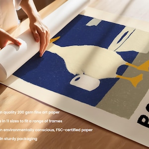 May include: A rolled-up art print featuring a whimsical illustration of a white duck with yellow feet and a white jug against a blue and beige background. The word "POOPT" is printed in black on the right side of the print.