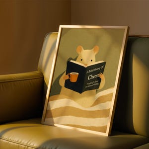 May include: Framed print depicting a cartoon mouse reading a book titled "A Brief History of Cheese." The mouse holds an orange mug. The background is light green, and the mouse is in a bed with striped bedding. The frame is wooden.