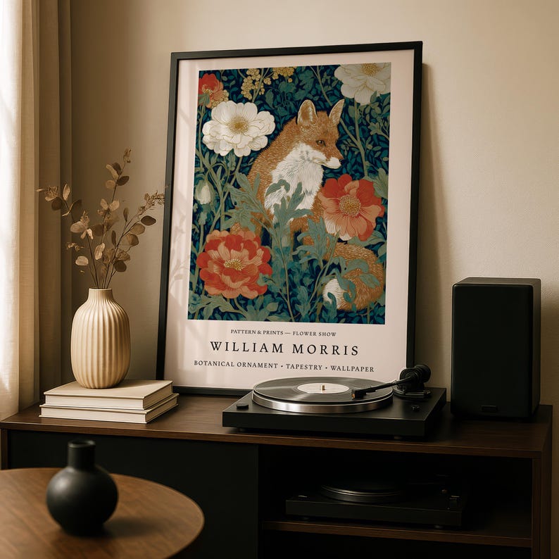 a framed poster of a fox surrounded by flowers, placed on a wooden shelf next to a record player and other decorative items.