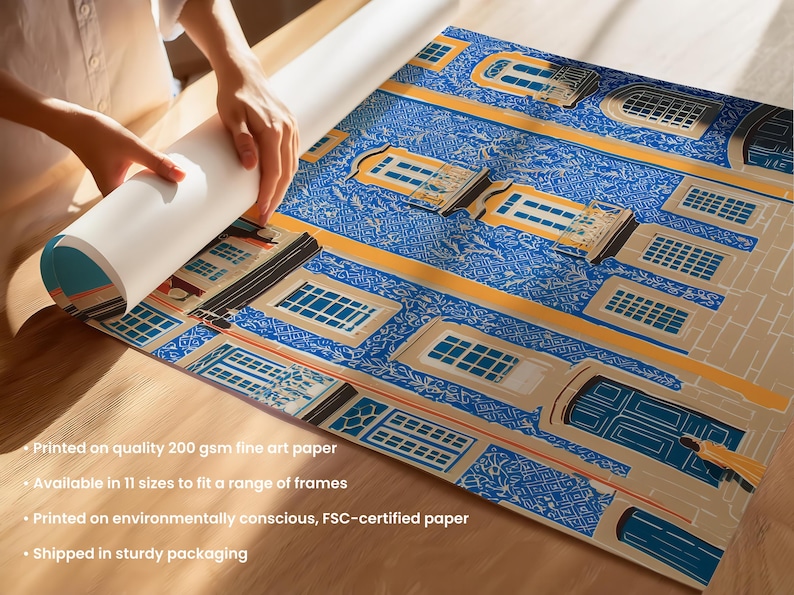 K&ouml;nnte beinhalten: Gerollter Kunstdruck mit detailliertem Architekturdesign in Blau, Beige und Gelb. Der Druck zeigt ein sich wiederholendes Muster von Geb&auml;udefassaden mit Fenstern und T&uuml;ren. Das Papier wird auf einer Holzoberfl&auml;che ausgerollt.