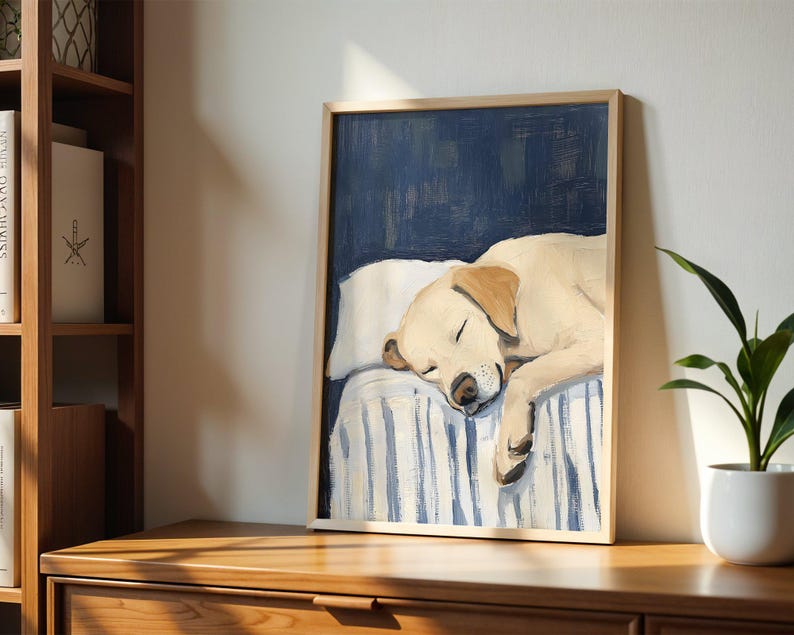K&ouml;nnte beinhalten: Ein Gem&auml;lde eines Golden Retriever Hundes, der auf einem blau-wei&szlig; gestreiften Bett schl&auml;ft. Der Hund liegt zusammengerollt mit dem Kopf auf dem Kissen. Das Gem&auml;lde ist in einem hellen Holzrahmen gerahmt.