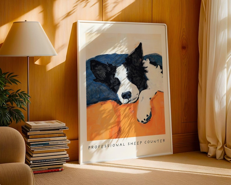 Dog art print of Border Collie with orange background, leaned against wall beside books and lamp – rustic dog lover gift.
