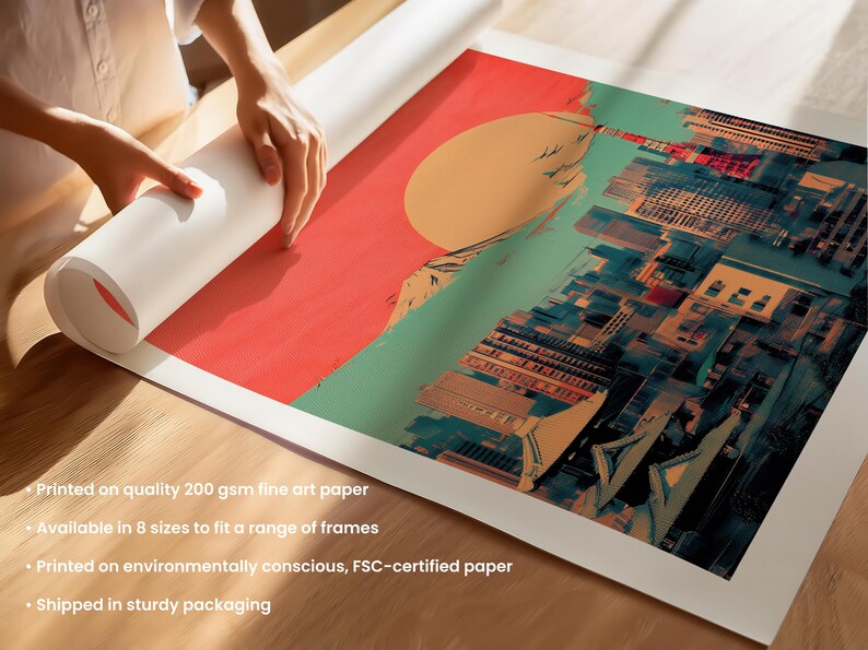 May include: A colorful print of a cityscape with a large red sun in the background. The print is rolled up and being held by a person's hand. The print is printed on high-quality 200 gsm fine art paper and is available in 8 sizes to fit a range of frames. It is printed on environmentally conscious, FSC-certified paper and shipped in sturdy packaging.