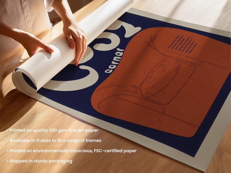May include: An art print with a mid-century modern style illustration of an orange armchair on a navy blue background. The word "Corner" is in white, stylized text. The print is being unrolled. The paper is 200 gsm.