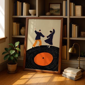 以下が含まれることがあります： レコードの上で踊る2人の人物を描いた、額入りのアートプリント。人物はネイビーとオレンジ色の服を着ており、クリーム色の背景に設定されています。プリントは茶色の木製フレームに入っており、本棚と鉢植えのある部屋に飾られています。