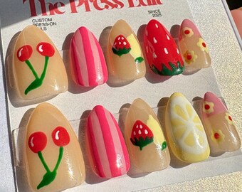 Unghie finte con design misto e frutta estiva.