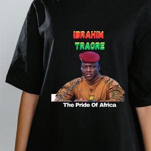 May include: Black t-shirt featuring a portrait of Ibrahim Traore with the text "IBRAHIM TRAORE" in red, green, and yellow. Below the portrait, the text reads "The Pride Of Africa."