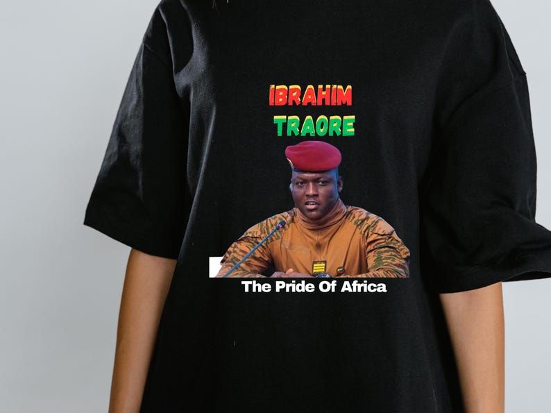 May include: Black t-shirt featuring a portrait of Ibrahim Traore with the text "IBRAHIM TRAORE" in red, green, and yellow. Below the portrait, the text reads "The Pride Of Africa."