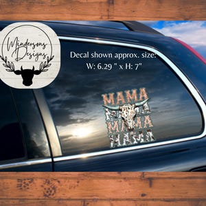 Puede incluir: Una calcomanía en la ventana de un coche con la palabra "MAMA" apilada tres veces, con un gráfico de calavera de vaca. La calcomanía mide aproximadamente 16 cm de ancho y 18 cm de alto. El diseño incluye un logotipo con una silueta de vaca y el texto "Mindersons Designs".