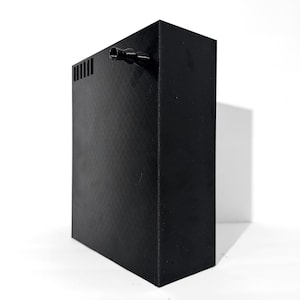 Könnte beinhalten: Schwarze rechteckige Filterbox mit einem kleinen schwarzen Schlauch, der oben herausragt.