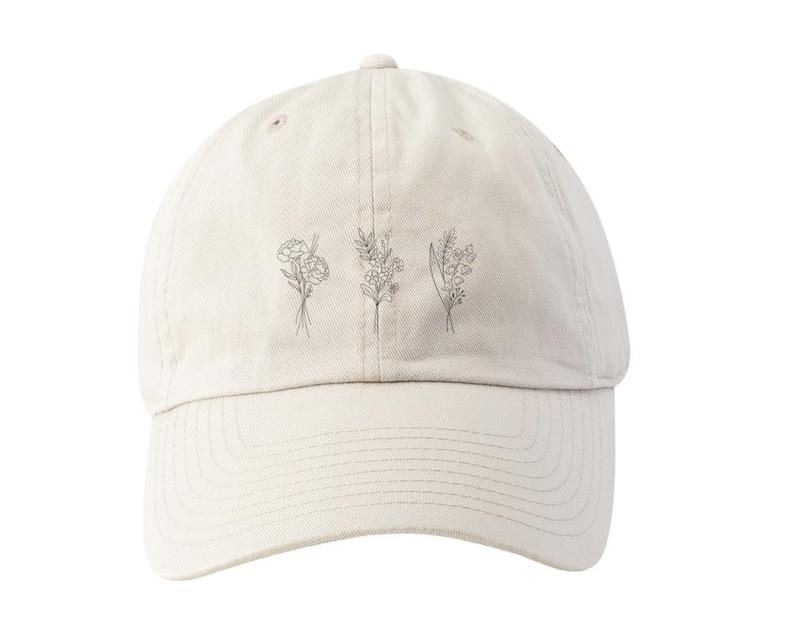May include: A beige baseball cap with a simple line drawing of four different flowers on the front.