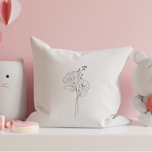 May include: White pillow with a simple line drawing of a flower bouquet on it.
