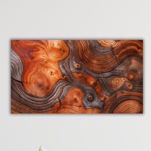 Op de afbeelding: Close-up van een houten kunstwerk met een gedetailleerd patroon van wervelende houtnerf. Het kunstwerk toont een rijk palet aan warme bruin- en roodoranje tinten, met donkerdere, contrasterende grijsbruine secties. De natuurlijke houtnerf creëert een unieke, organische textuur.