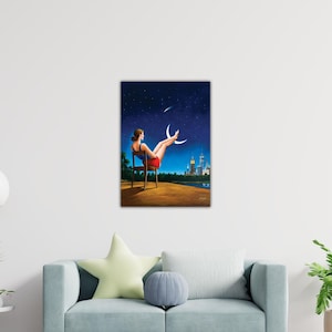 May include: A framed art print depicts a woman in a red skirt and blue top, seated in a chair, with her legs raised towards two crescent moons. The background shows a starry night sky, a city skyline, and a body of water.