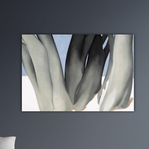 May include: Abstract painting featuring a close-up of organic shapes in shades of gray, black, and white against a light blue and white background. The artwork is mounted on a wall, showcasing a modern aesthetic.