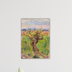 May include: An impressionistic painting of a tree with yellow blossoms. The tree's brown trunk twists upwards, set against a backdrop of green grass, orange and blue sky. The artwork is framed and mounted on a white wall.