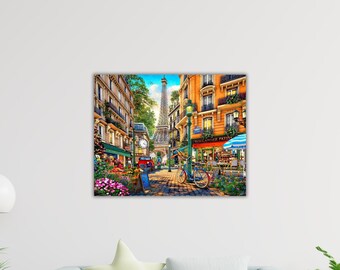 May include: A colourful painting depicting a Parisian street scene with the Eiffel Tower visible. The image shows a cafe with a blue and white striped parasol, a bicycle, and flowers. Buildings line the cobbled street.
