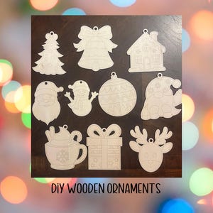 Puede incluir: Una colección de adornos navideños de madera DIY en varias formas, incluyendo un árbol de Navidad, campana, casa, Papá Noel, muñeco de nieve, bola de adorno, gnomo, taza de café, caja de regalo y reno. El texto "DIY WOODEN ORNAMENTS" está en la parte inferior.
