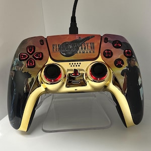 Könnte beinhalten: Vergoldeter PlayStation 5-Controller mit einem individuellen Design, das das Logo und die Charaktere von Final Fantasy VII Remake zeigt. Der Controller hat rote Tasten und ein Schwarz-Gold-Farbschema.